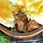 British Steak an Ale Pie with a piece of puff pastry missing.
