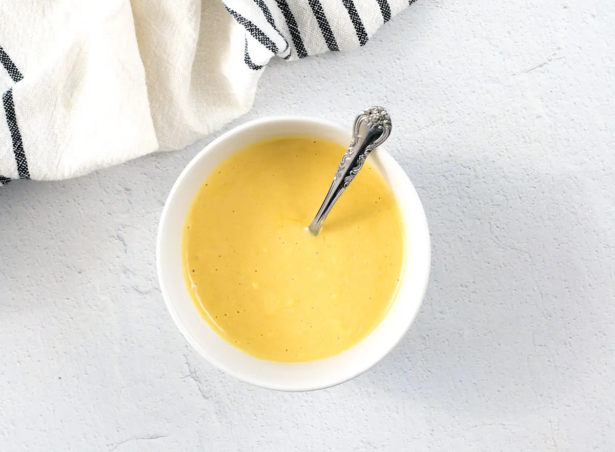 Smoked Sausage Recipe (Easy Smoking Recipe) 4 Honey mustard in a white bowl with a silver spoon.