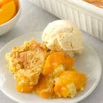 Slice of peach dump cake and ice cream.
