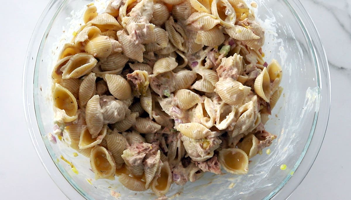 Pasta salad with tuna in a clear bowl.