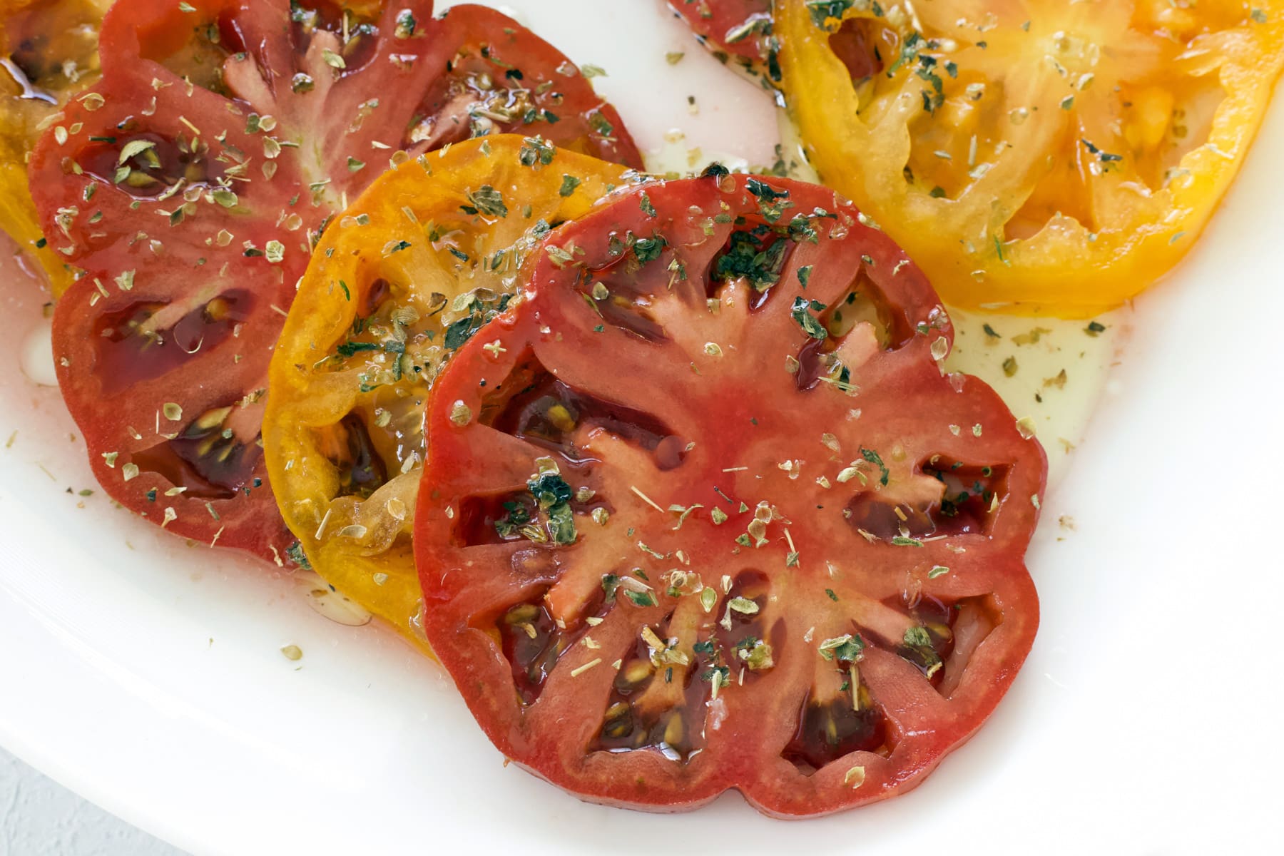 Marinated heirloom tomato slices topped with dried herbs.