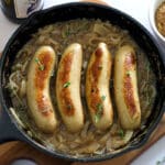 Bratwurst browning in a cast iron skillet for beer brats.