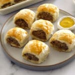 Sausage Roll on a grey plate with mustard dipping sauce.