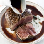 Red Wine Steak Sauce being poured over a baked filet mignon.
