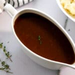 Gravy bowl full of brown gravy.