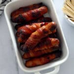 Pigs in a blanket in a white serving dish.